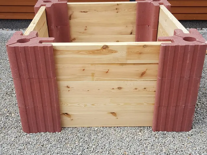 Quadratisches Hochbeet aus roten Vablo Ecksteinen und hellen Holzbohlen