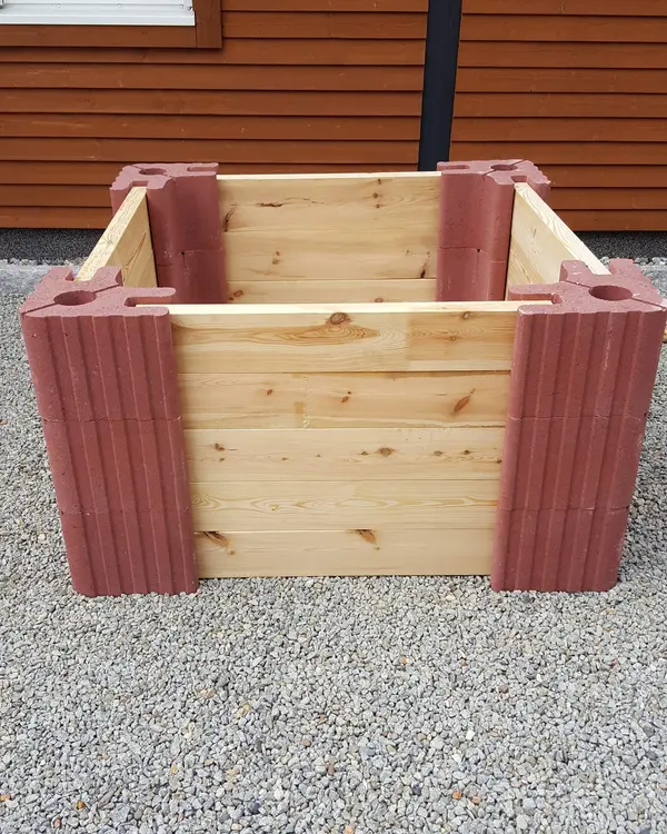 Quadratisches Hochbeet aus roten Vablo Ecksteinen und hellen Holzbohlen